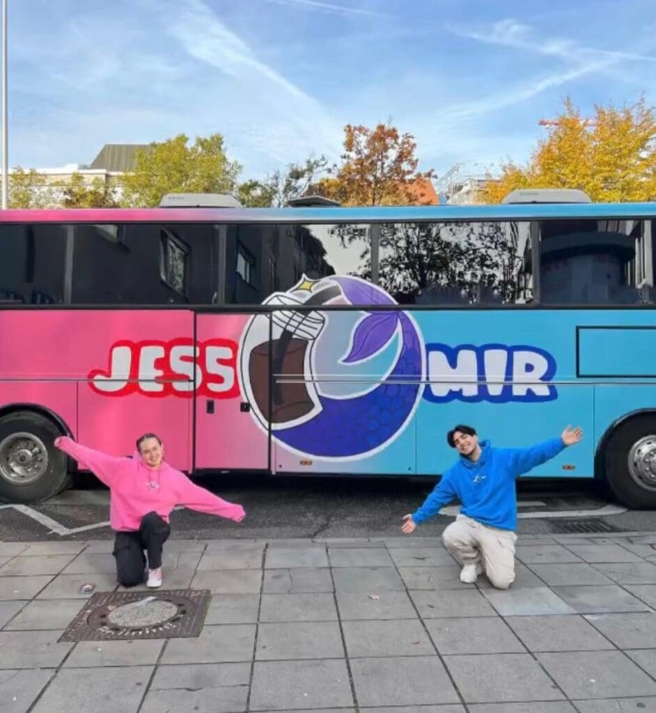 zwei Influenzer vor einem Bus in Rosa und Blau mit dem Schriftzug JESS links und MIR rechts